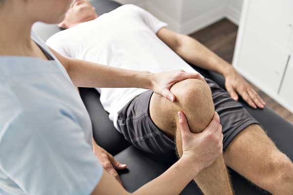 patient-receiving-physiotherapy-on-knee-by-med1care-therapist