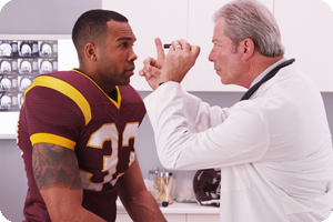 Doctor examining college football player for concussion injury.
