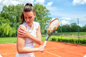 Woman holding shoulder on tennis court.