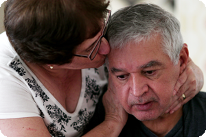 Wife comforting husband who suffers from alzheimers disease.